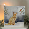 Snow Cat Christmas card on a mantlepiece