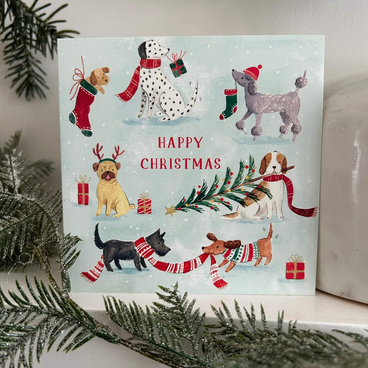 Festive Dogs Christmas card on a mantlepiece
