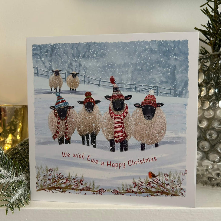 Sheeps with scarves and hats in snowy a field 