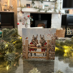 Donkeys in scarves Christmas, with a festive fireplace in the background