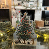 Christmas Tree die card, with a festive fireplace in the background