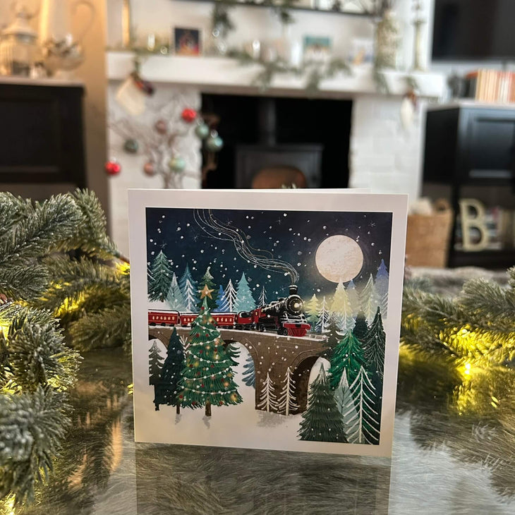 Christmas steam train card, with a festive fireplace in the background