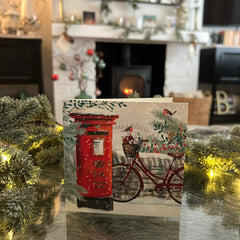 Snowy Postbox Christmas card, with a festive fireplace in the background