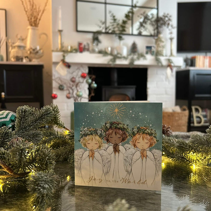 Angels Together Christmas card, with a festive fireplace in the background