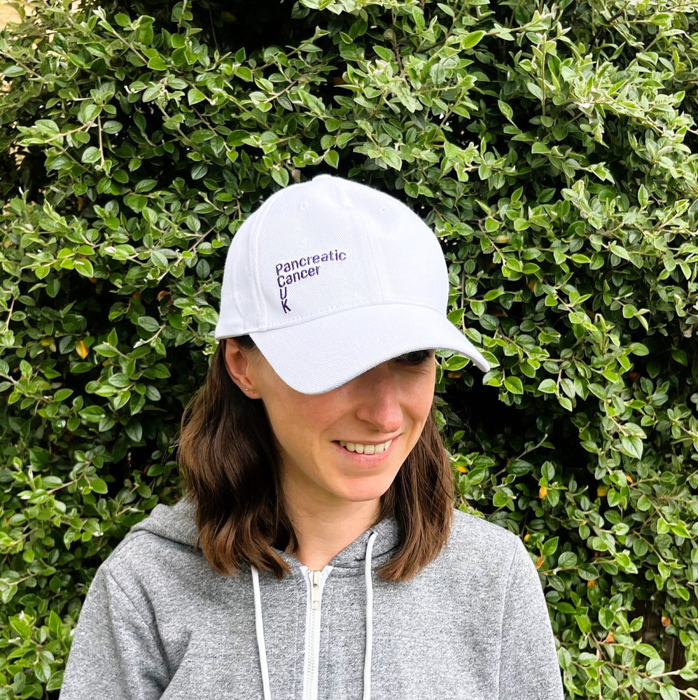 White cap with purple Pancreatic Cancer UK logo on front and side